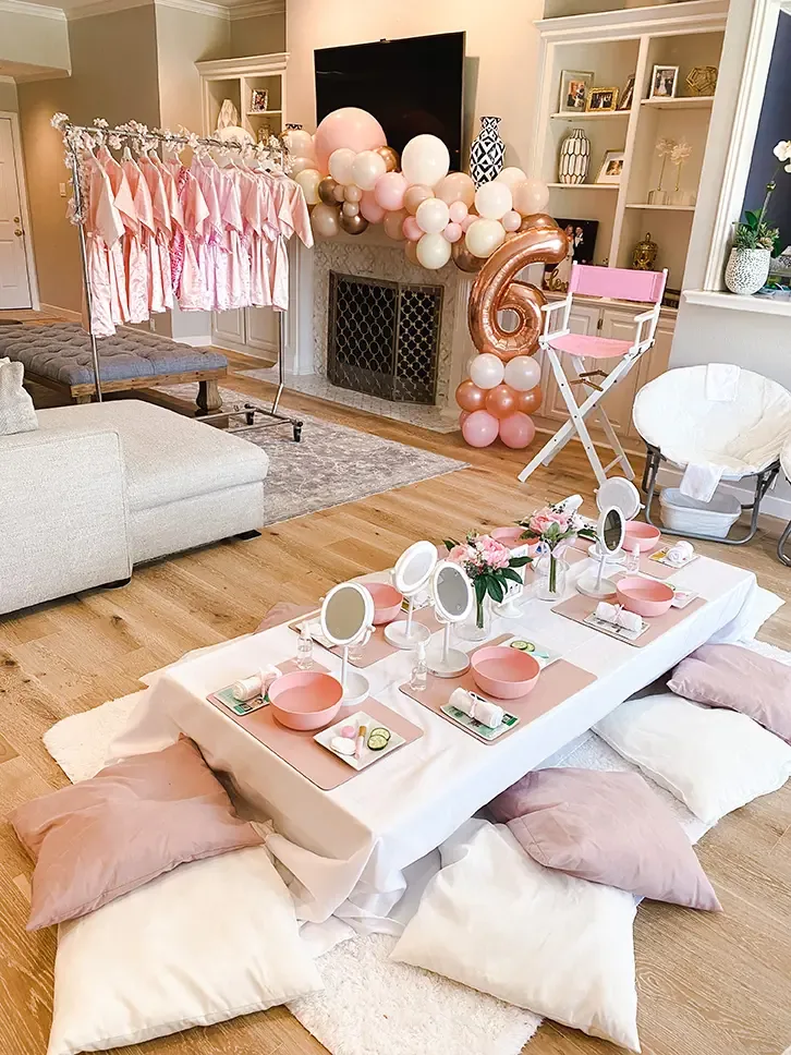 Fiesta de spa con perchero de batas, mesa de spa decorada y espejos en forma de nube
