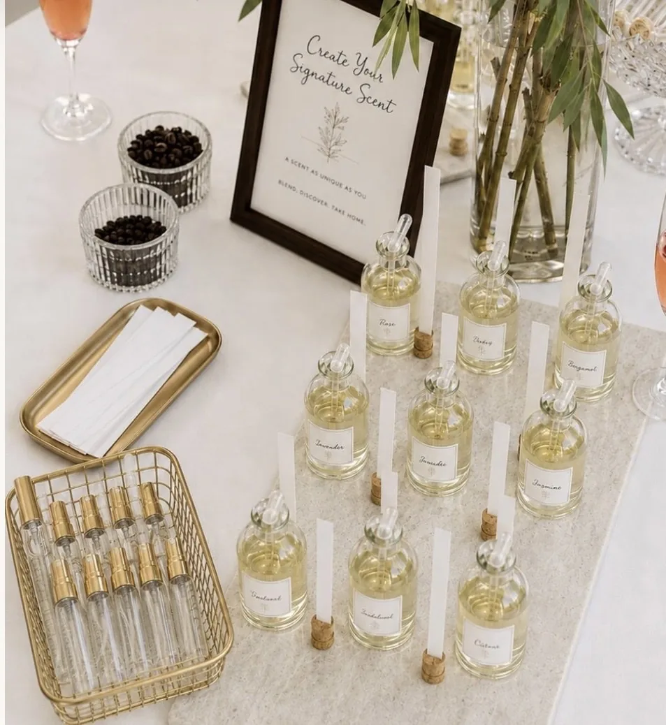Fragrance bottles with labeled scents, scent strips and empty spray bottles on a styled table
