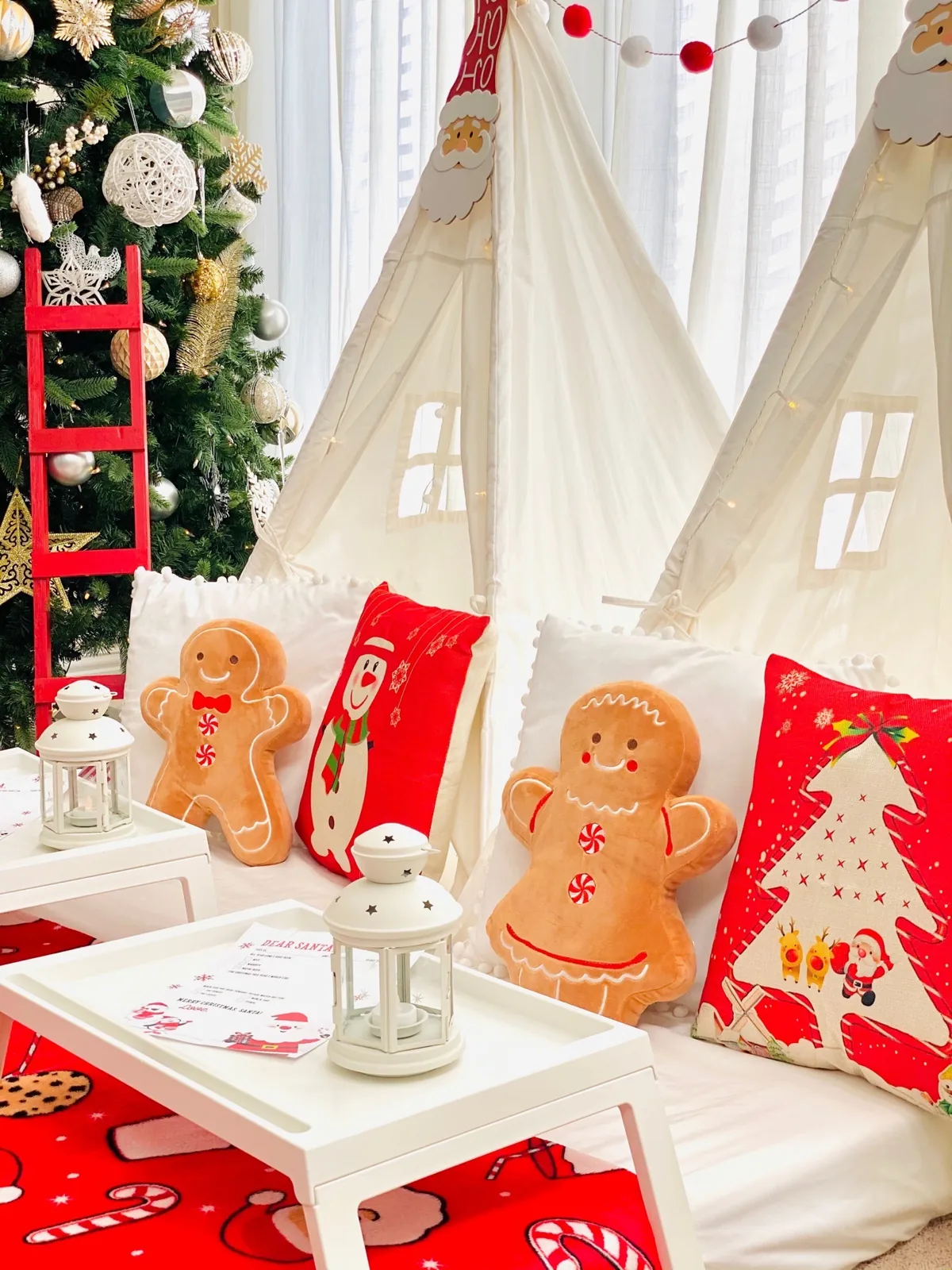 Christmas teepees beside a decorated tree with gingerbread pillows